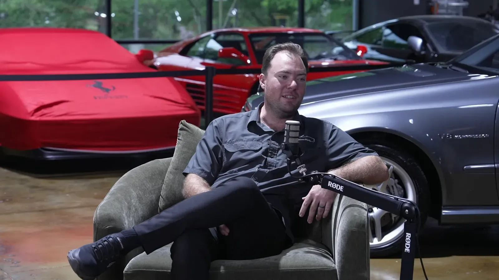Cameron Davis talking on the Throttlecast set at The Ride Lounge, cars on the floor behind