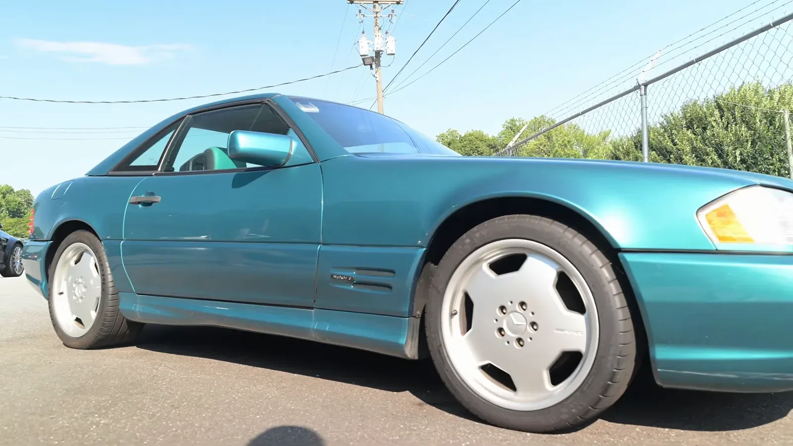 A Calypso Green 1997 Mercedes SL La Costa edition parked in the sun outside DC MotorWerks