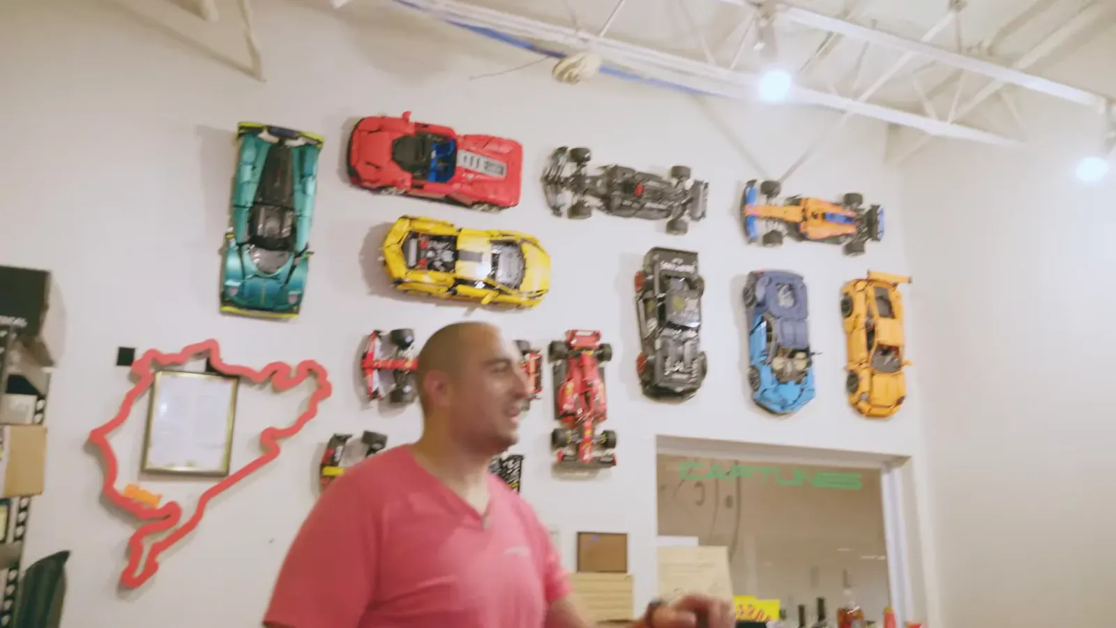 Emran Alborno in his office, a wall of Lego car builds behind him