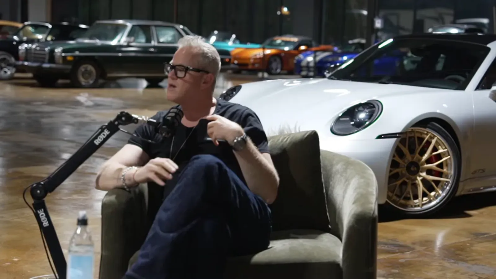 Dani Butler talking on the Throttlecast set at The Ride Lounge, cars on the floor behind