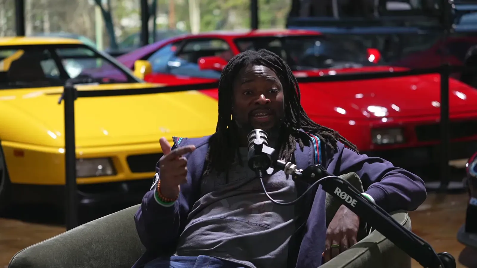 David Middleton talking on the Throttlecast set at The Ride Lounge, cars on the floor behind