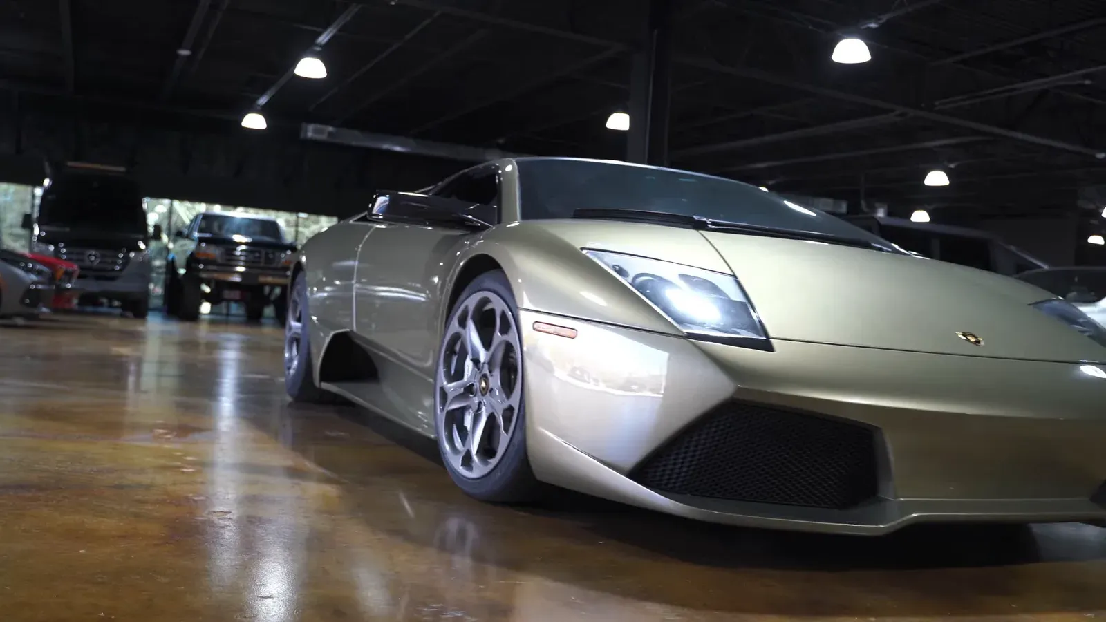 Ed Bolian’s green Lamborghini Murciélago LP640 seen low from the front three-quarter on the lounge floor