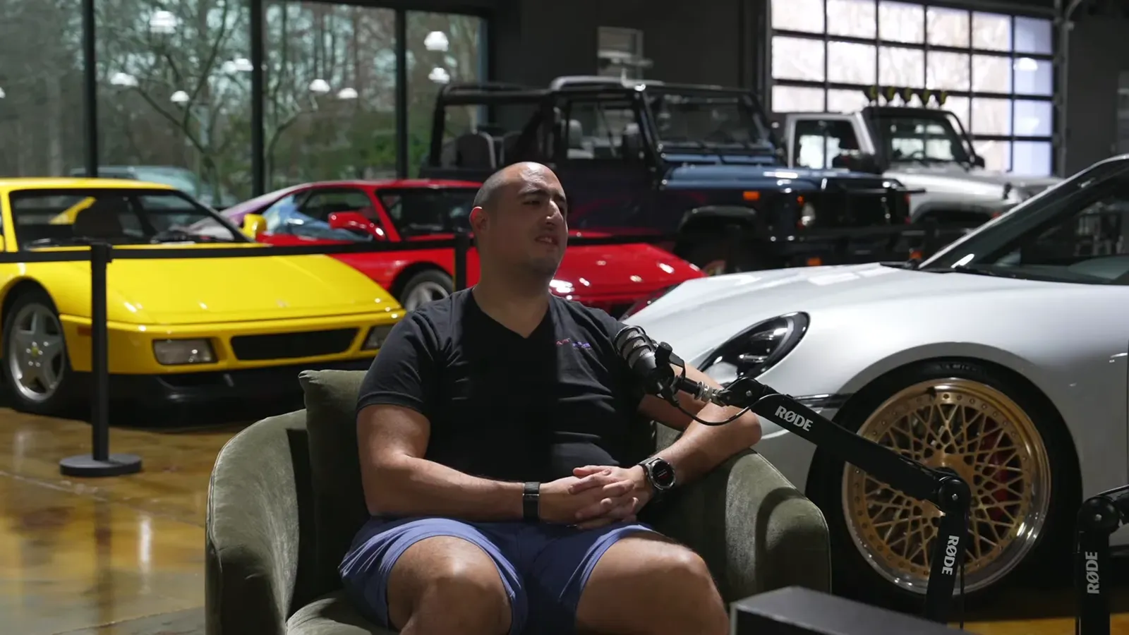 Emran Alborno talking on the Throttlecast set at The Ride Lounge, cars on the floor behind