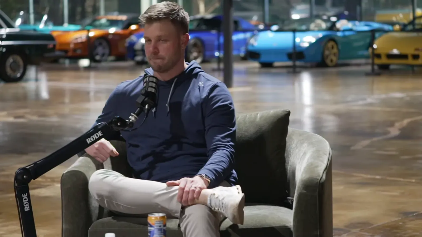 Evan Halliday talking on the Throttlecast set at The Ride Lounge, cars on the floor behind