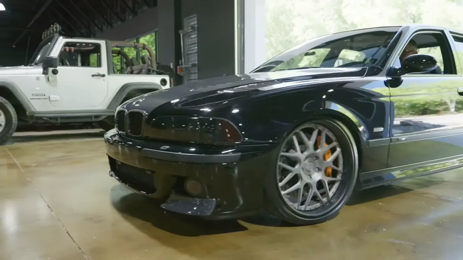 Jason Cummins’s black BMW E39 M5 rolling through the door into The Ride Lounge