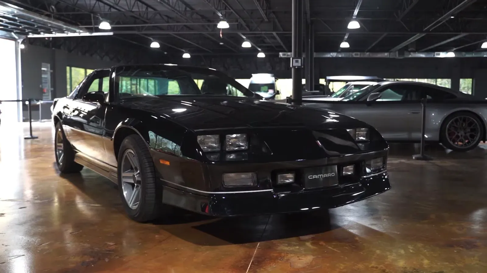 Jim Florek’s black 1987 Chevrolet Camaro IROC-Z parked on the lounge floor, front three-quarter view