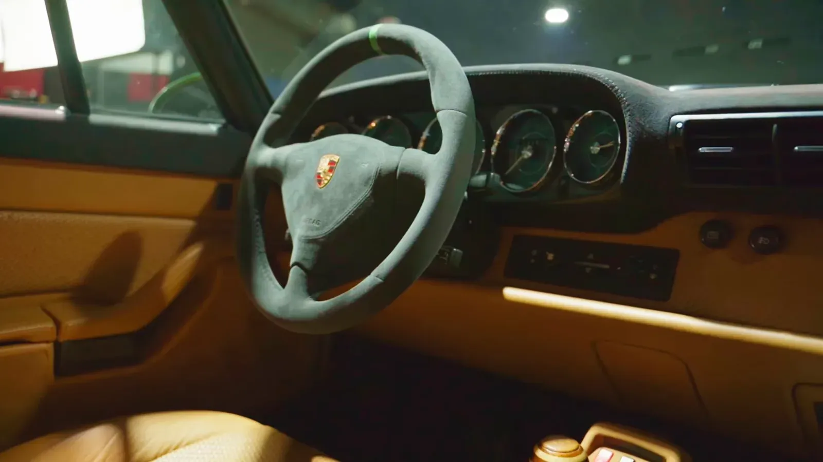 Interior of Matt Kossoff’s 993 Turbo, with tan leather on the dash and door and a green steering wheel