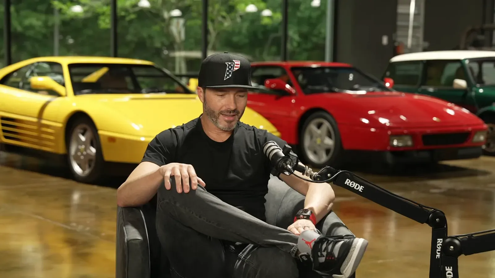 Ryan Hardwick talking on the Throttlecast set at The Ride Lounge, cars on the floor behind