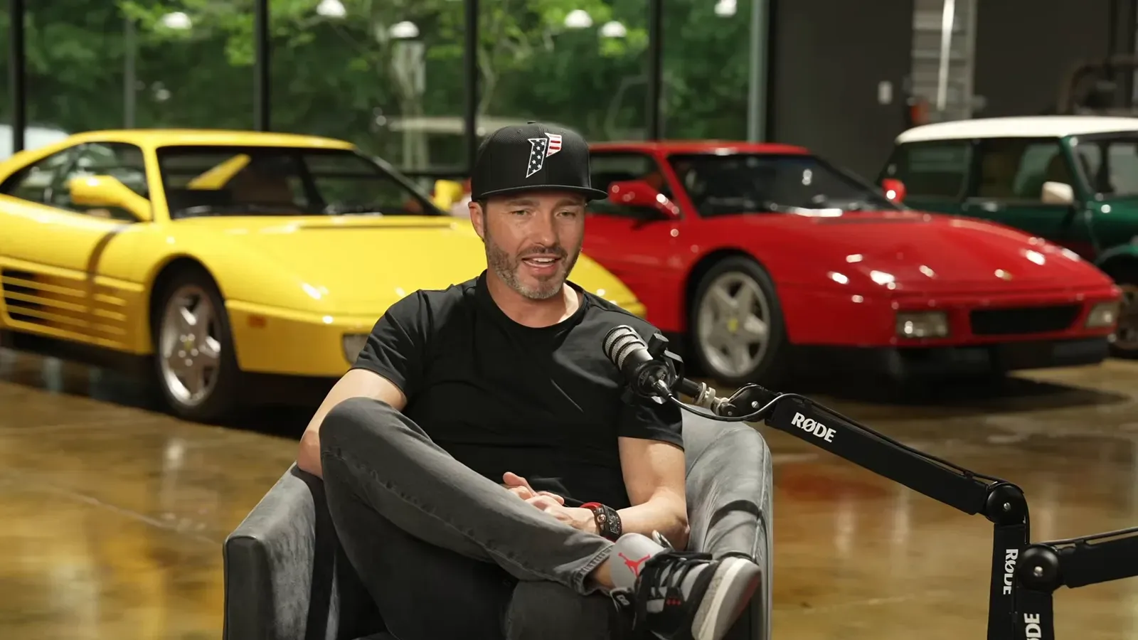 Ryan Hardwick talking on the Throttlecast set at The Ride Lounge, cars on the floor behind