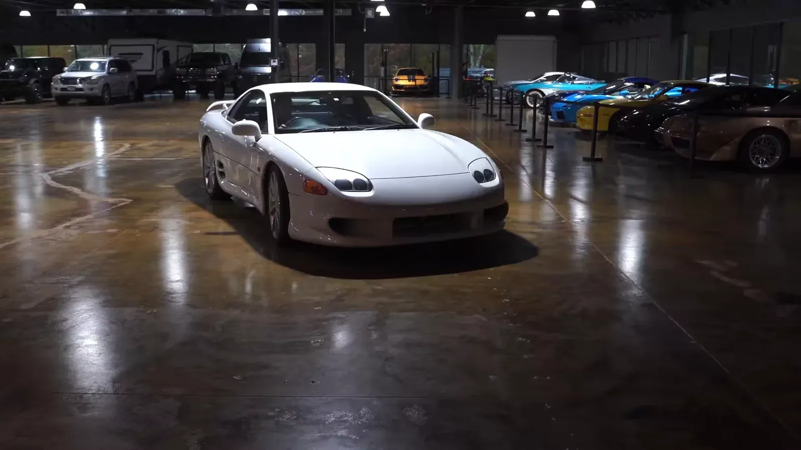 A white Mitsubishi GTO MR driving across the lounge floor, seen from the front