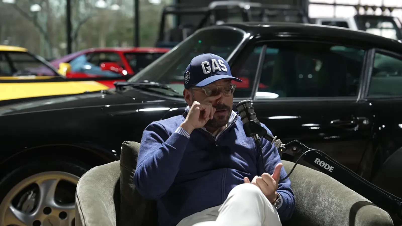 Tony Marzullo talking on the Throttlecast set at The Ride Lounge, cars on the floor behind